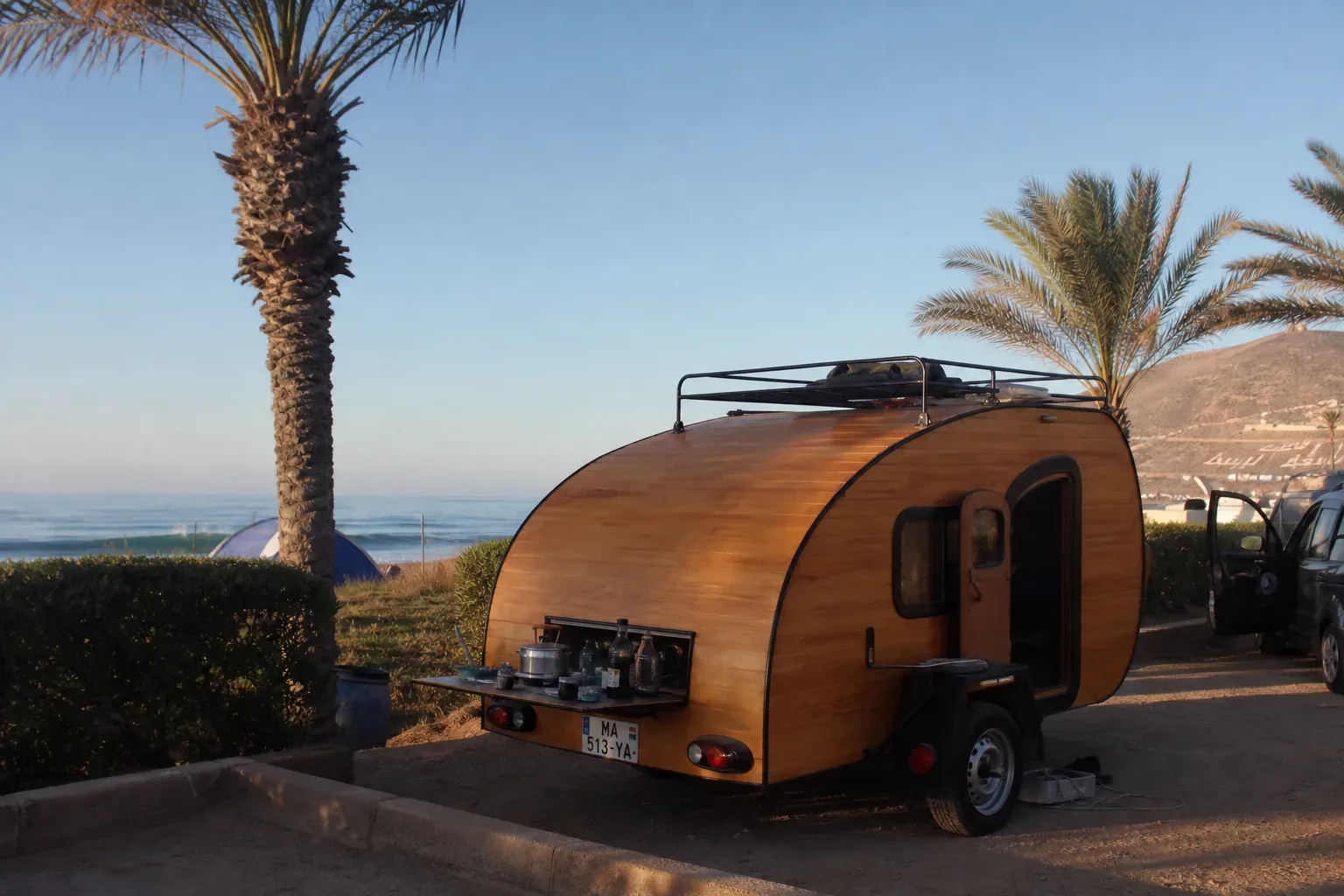 Caravane teardrop dans une aire de camping-car sur la côte d'Agadir avec palmiers