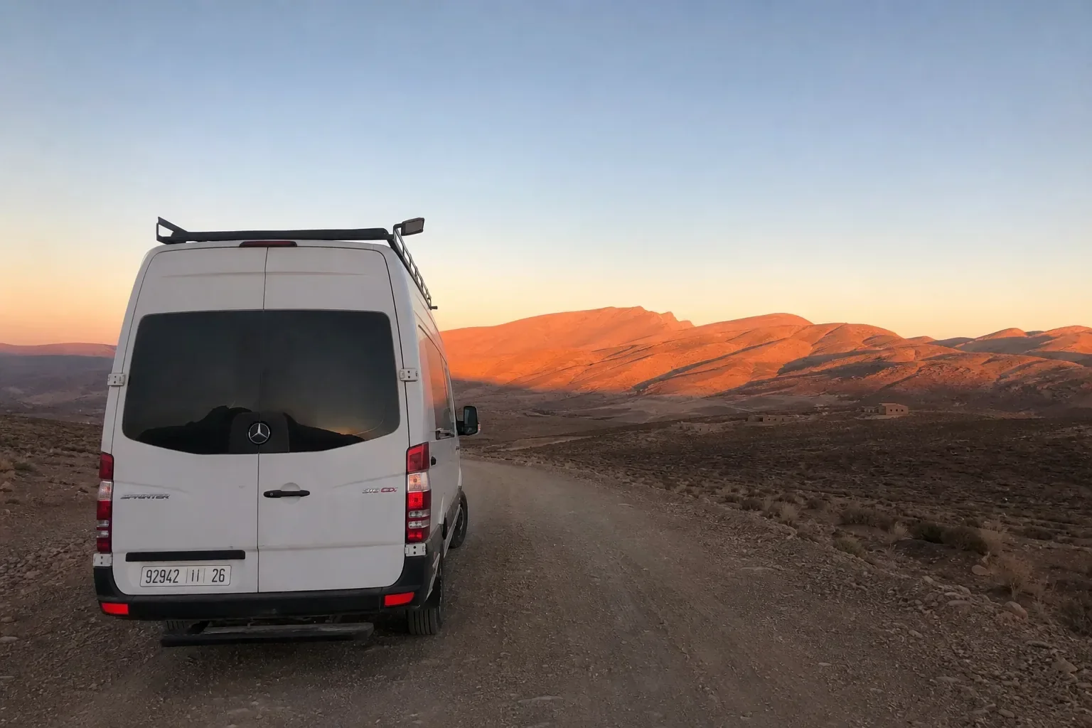 Van aménagé sur une piste marocaine, coucher de soleil sur les montagnes de l'Anti-Atlas