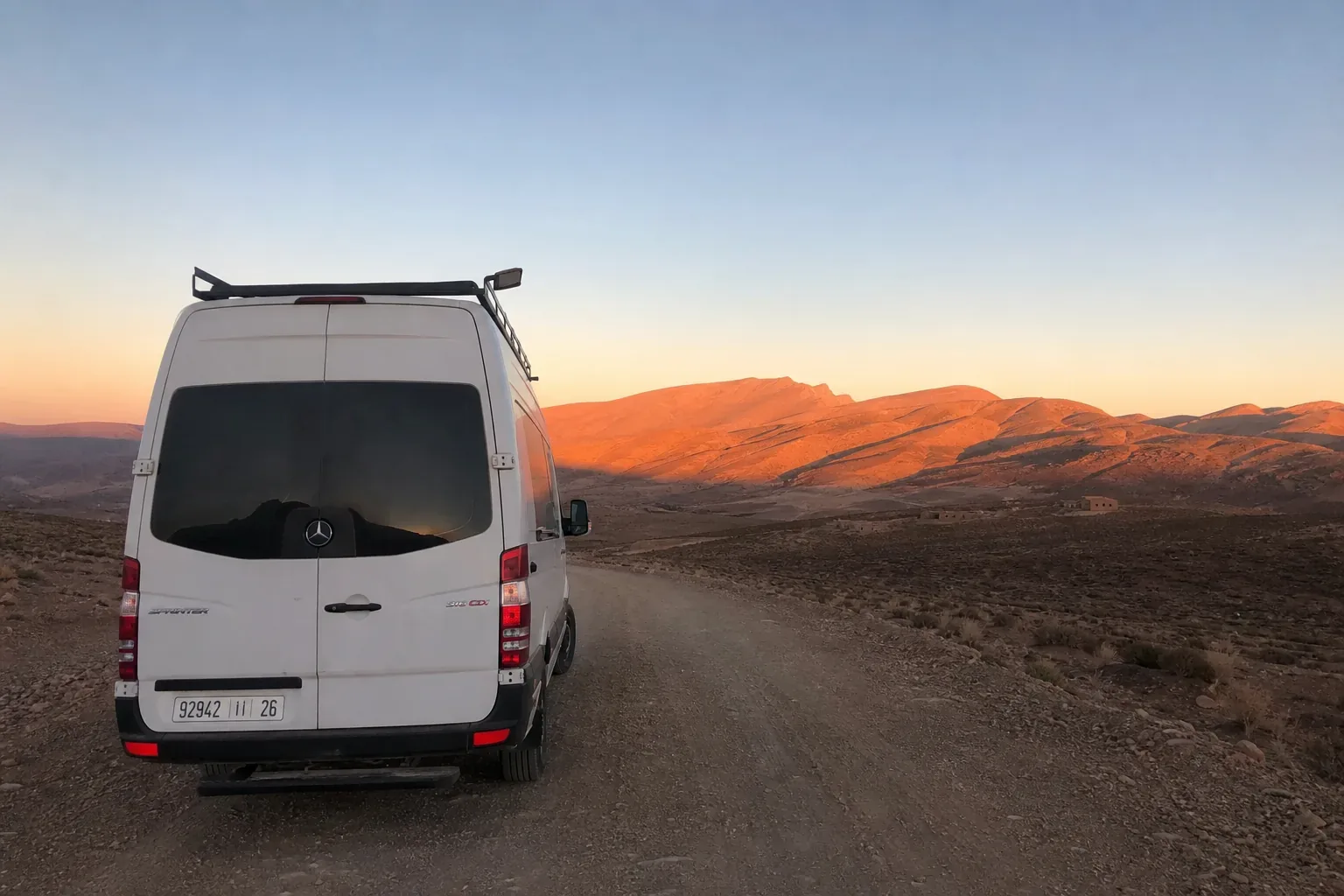 Van Mercedes Sprinter aménagé sur une piste marocaine au coucher de soleil